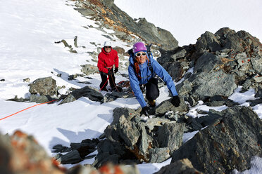 Mountaineer climbing up snow covered mountain, Saas Fee, Switzerland - CUF14202