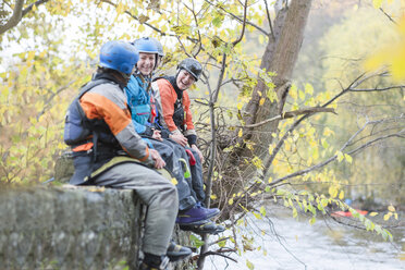 Männlicher und weiblicher Kajakfahrer sitzen lachend an der Ufermauer, Fluss Dee, Llangollen, Nordwales - CUF14206