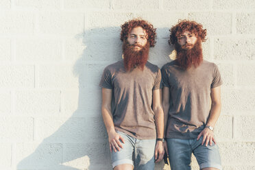 Porträt von eineiigen erwachsenen männlichen Zwillingen mit roten Haaren und Bärten vor einer Wand - CUF14208