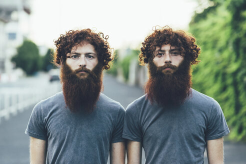 Portrait of identical adult male twins with red hair and beards on sidewalk - CUF14214