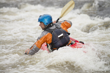 Rear view of male kayaker paddling River Dee rapids - CUF14228