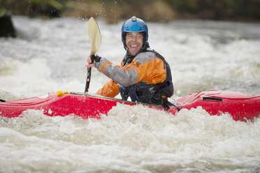 Happy male kayaker paddling River Dee rapids - CUF14232