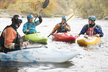 Male and female kayakers having team talk on River Dee, Llangollen, North Wales - CUF14235