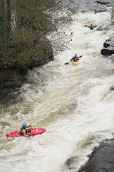 High angle view of kayakers paddling River Dee white water rapids, Llangollen, North Wales - CUF14237