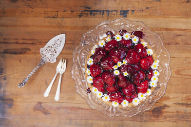 Hausgemachter Erdbeerkuchen mit roter Traubensaftglasur und Gänseblümchendekoration auf altem Kuchenständer - GWF05518