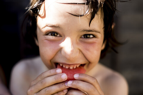 Glücklicher Junge isst Wassermelone an einem Sommertag, lizenzfreies Stockfoto