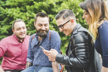 Group of friends looking at message on cellphone - CUF14250