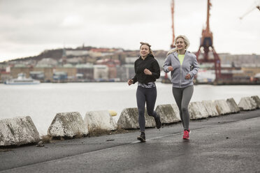 Zwei befreundete Läuferinnen laufen entlang des Hafens - CUF14270