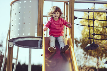 Porträt eines kleinen Mädchens auf einer Rutsche auf einem Spielplatz - JSMF00206