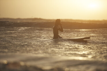 Silhouette eines jungen männlichen Surfers mit Surfbrett im Meer, Devon, England, UK - CUF14335
