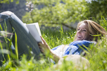 Frau liegt im Gras und liest - CUF14424