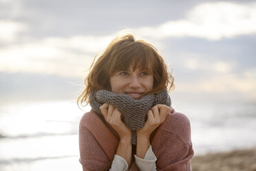 Woman wearing snood looking away smiling - CUF14447