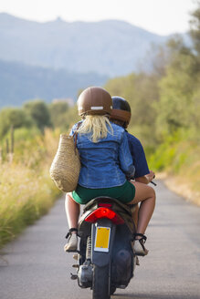 Rückansicht eines jungen Paares beim Mopedfahren auf einer Landstraße, Mallorca, Spanien - CUF14484