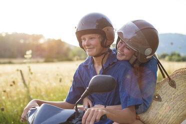 Romantic young couple riding moped on rural road, Majorca, Spain - CUF14485