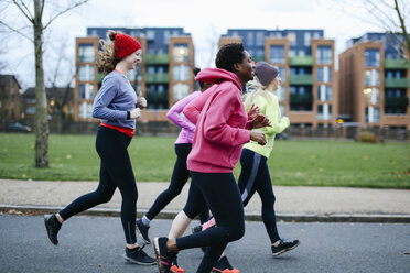 Five female runners running along city sidewalk - CUF14595