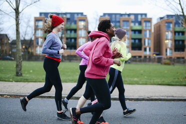 Fünf Läuferinnen laufen auf dem Bürgersteig der Stadt - CUF14595