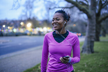 Young woman in exercise clothes, wearing earphones - CUF14597