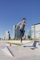 Sportive man jumping in a skatepark in the city - MAUF01401