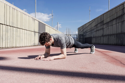 Sportlicher Mann beim Training im Freien zwischen Mauern, lizenzfreies Stockfoto
