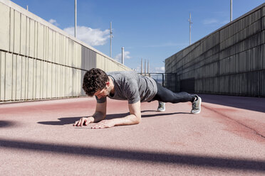 Sportive man exercising outdoors between walls - MAUF01413