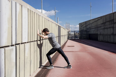 Sportive man exercising at a wall - MAUF01417