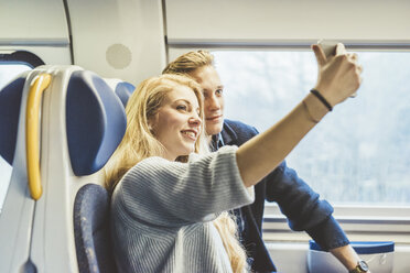 Junges Paar macht Smartphone-Selfie im Zugwaggon - CUF14611