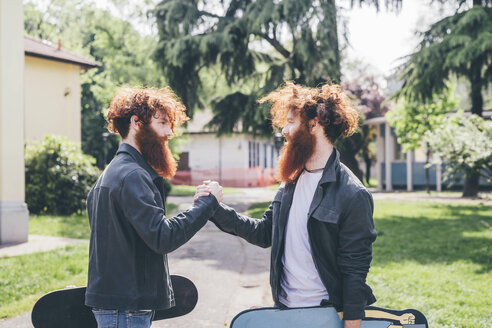 Young male hipster twins with red beards shaking hands in park - CUF14647