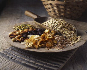 Dried fruits, nuts and oats on wooden plate - CUF14704