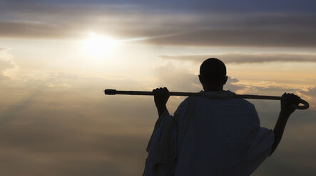 Man with stick watching sunset, Lalibela, Ethiopia - CUF14745