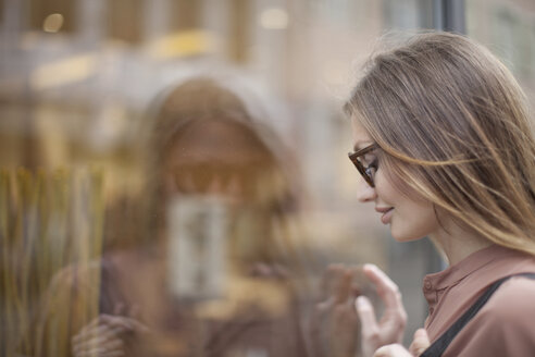 Schöne Frau beim Betrachten eines Schaufensters, Freiburg, Deutschland - CUF14781