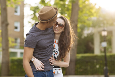 Young couple walking in street face to face smiling - CUF14795