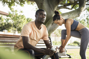 Mann in Sportkleidung sitzt auf einer Parkbank und schaut weg - CUF14821