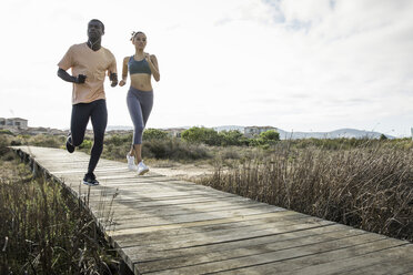 Couple jogging on wooden walkway - CUF14823