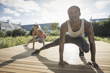 Couple crouching stretching legs - CUF14832