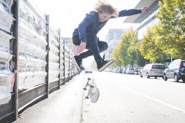 Young male urban skateboarder doing skateboard jump on road - CUF14846