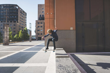 Young male skateboarder skateboarding up urban step - CUF14854