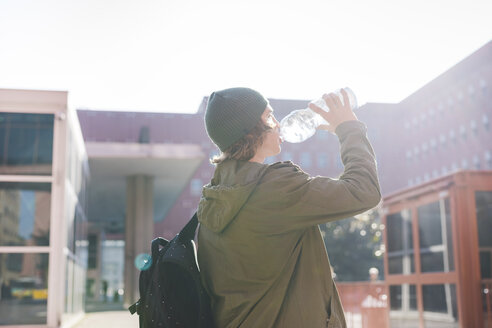 Junger urbaner Mann trinkt aus einer Wasserflasche - CUF14859