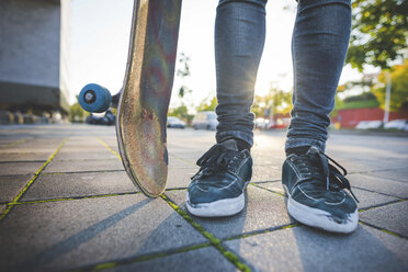 Legs and feet of young male urban skateboarder standing on sidewalk - CUF14873