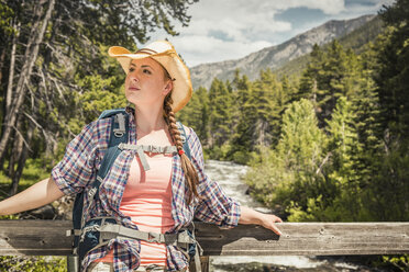 Junge Wanderin blickt von einem Steg über den Fluss, Red Lodge, Montana, USA - CUF14891