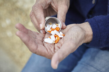 Woman dispensing pills from pill bottle into hand - CUF14953