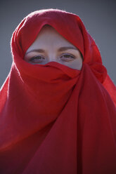 Porträt einer jungen Frau mit rotem Schleier im Gesicht - CUF14973