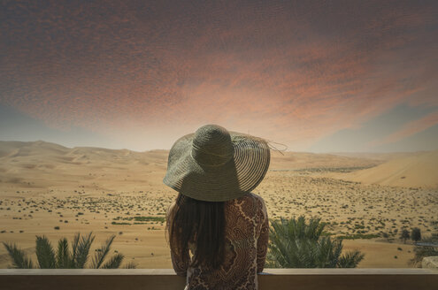 Frau auf Balkon, mit Blick auf die Wüste, bei Sonnenuntergang, Rückansicht, Abu Dhabi, Emirat Abu Dhabi, VAE - CUF14976