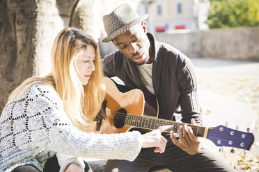 Ehepaar lernt im Park Gitarre zu spielen - CUF14986