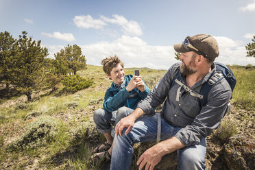 Teenage boy photographing father on hiking trip, Cody, Wyoming, USA - CUF15054