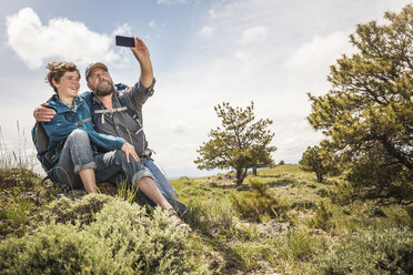 Father and teenage son taking smartphone selfie on hiking trip, Cody, Wyoming, USA - CUF15056