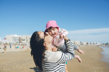 Frankreich, La Baule, Mutter küsst glückliches kleines Mädchen am Strand - GEMF02029