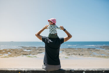 Rückenansicht eines Vaters mit seiner kleinen Tochter auf den Schultern am Strand - GEMF02039