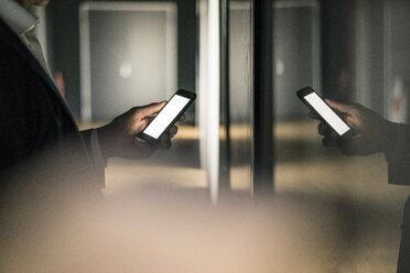 Glänzendes Mobiltelefon in der Hand eines Geschäftsmannes - JOSF02185