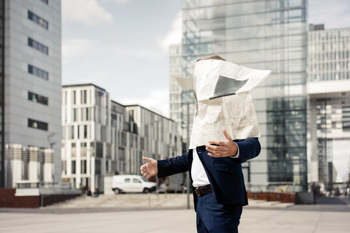 Newspaper covering businessman's face in the city - JOSF02189