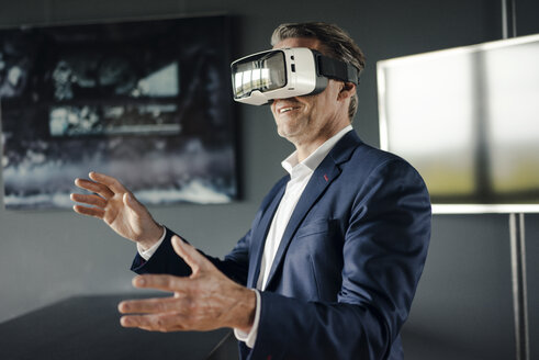 Reifer Geschäftsmann mit VR-Brille im Büro - JOSF02195